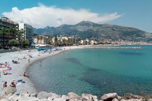a beach with a bunch of people in the water at LE CAP - Superbe appartement, proche Monaco in Roquebrune-Cap-Martin