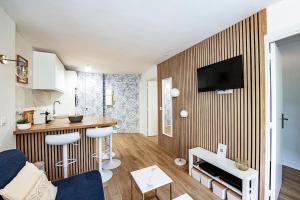 a living room with a kitchen with a counter and a kitchen at LE CAP - Superbe appartement, proche Monaco in Roquebrune-Cap-Martin