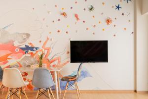 大阪市にあるV の Boutique Houseのテレビとテーブルと椅子のあるリビングルーム
