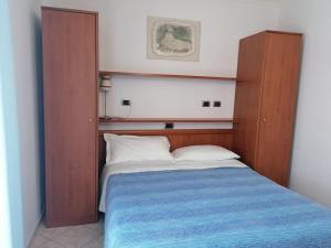 um quarto com uma cama com cabeceira de madeira em Albergo Ristorante Protti em Cattolica