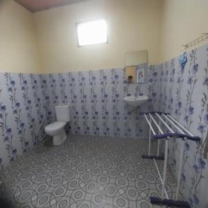 a bathroom with a toilet and a sink at Donny Guesthouse in Tuk Tuk