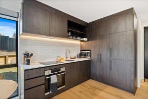 a kitchen with dark wood cabinets and a sink at Mt Roy Delight in Wanaka