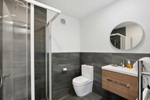 a bathroom with a toilet and a sink and a mirror at Mt Roy Delight in Wanaka