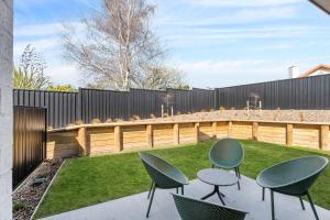 a patio with four chairs and a fence at Mt Roy Delight in Wanaka +9 photos