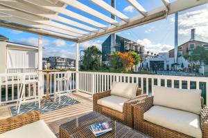a patio with wicker chairs and tables on a balcony at Turbine Villa in Knysna