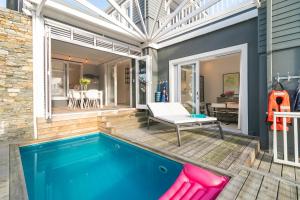 a swimming pool in a house with a patio and a house with a swimming pool at Turbine Villa in Knysna