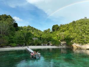 a group of people sitting on a dock in the water at The Angkayo in Angkayo