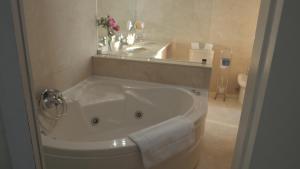 y baño con bañera y espejo. en Bartolomeu Beach Apartments, en Oporto