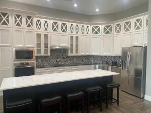 a kitchen with white cabinets and a counter with stools at Luxury in Spacious Home in Horseshoe Bay