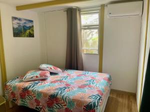 a bedroom with a bed with pillows and a window at Saline les bains petite maison bien aménagée calme & plage à pied in La Saline les Bains
