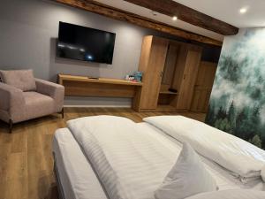 a bedroom with a bed and a tv and a chair at Goldener Stern in Goslar +77 photos