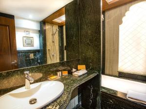 um banheiro com uma pia e um espelho em Hotel Bawa Continental em Mumbai mais 37 fotografias