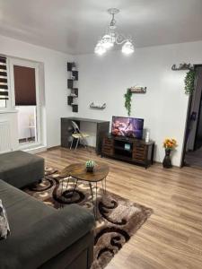 un soggiorno con un divano, un tavolo e una TV di Chic Urban Retreat a Drîmbar Altre 14 foto
