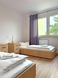 two beds in a room with a window at YiPY Apartments - Halle in Halle an der Saale