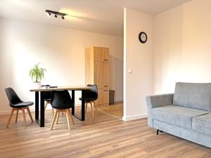 a living room with a table and chairs and a couch at YiPY Apartments - Halle in Halle an der Saale
