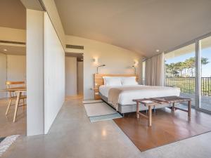 a bedroom with a bed and a table at Immerso Hotel, a Member of Design Hotels in Ericeira