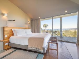 a bedroom with a large bed and a large window at Immerso Hotel, a Member of Design Hotels in Ericeira