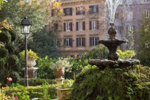 una fuente en un jardín frente a un edificio en Villa Matissa, en Roma