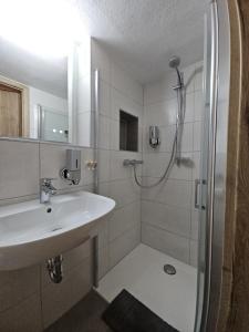 a bathroom with a sink and a shower at Gemütliche Ferienwohnung im Westerwald - "Ferienwohnung Grau" in Weitefeld +10 photos