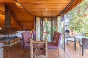 Un comedor con mesa y sillas y chimenea. en Casa De Cuento, en San Martín de Valdeiglesias