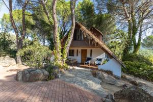 una casa con techo de paja y entrada de ladrillo en Casa De Cuento, en San Martín de Valdeiglesias