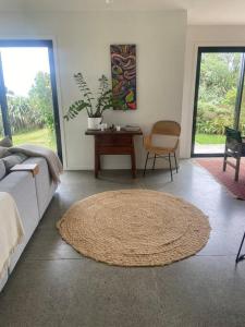 a living room with a couch and a rug at The Coastal Retreat in Raglan +88 photos