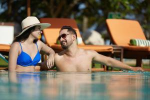 a man and a woman in a swimming pool at Pegasus Reef - A Beach Resort in Colombo in Colombo