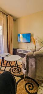 una sala de estar con un sofá y una mesa en Flat in Bukoto, Kampala, en Kyebando