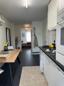 a kitchen with white cabinets and a wooden table at Eine schöne Wohnung bei der Erlenmatte in Basel