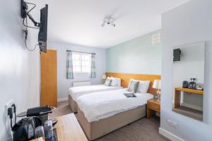 a hotel room with two beds and a television at Queen Street Tap in Deal