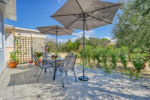 a table and chairs with an umbrella on a patio at Il Mio Riposo in Vasilikos