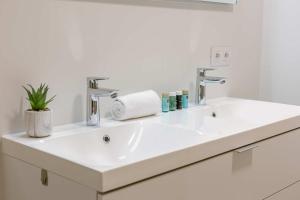 Huswell - Apartment with terrace close to the sea في أوستند: حمام مع حوض أبيض مع صنفين +25 صورة