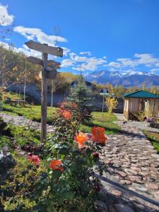 a sign in the middle of a garden with flowers at Jashylkent House in Vorontsovskoye