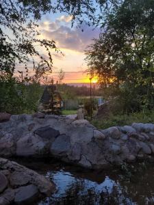 a sunset over a pond with the sun setting at Jashylkent House in Vorontsovskoye +14 photos