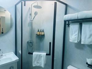 a shower with a glass door in a bathroom at IMMERSING Hotel Beijing Tiananmen Square Branch in Beijing