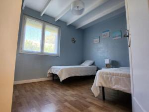 a room with two beds and a window at La Rose des vents in Saix