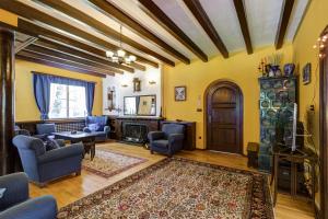 uma sala de estar com paredes amarelas e tectos em madeira em Villa Kalia em Borovets
