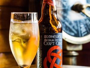 una bottiglia di birra seduta accanto a un bicchiere di The Beach, Days Bar and B&B a Inishbofin
