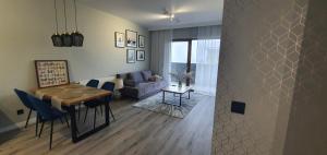 a living room with a table and a living room with a couch at Apartament REN in Częstochowa