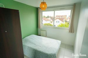 a green bedroom with a bed and a window at Escale-marne fr - 202 - Free Parking - Free Luggage Storage - Metro 8 Eiffel Tower - All equipped - Linen Included - Washing Machine - Panoramic View - From 1 to 18 guests in Maisons-Alfort