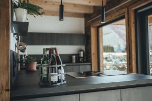 a kitchen counter with bottles of wine on it at Lechrain Chalet - 5 Sterne Ferienhaus - für 6 Personen - Biohof zwischen Ammersee und Lech in Reichling