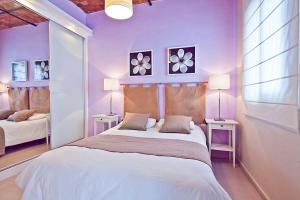 バルセロナにあるAtico Montserratの紫の壁のベッドルーム1室、ベッド1台(テーブル2台付)