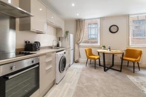 a kitchen with a sink and a table with chairs at WhiskAwayStays - Jenkins House - Apartment 1 in Worcester
