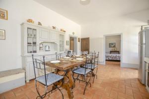 una cucina e una sala da pranzo con tavolo e sedie di Casale del Conte a Pienza