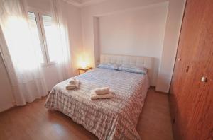 a bedroom with a bed with two towels on it at Apartamentos Bahía Alicante in Alicante