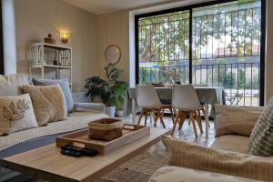 a living room with a couch and a table with chairs at Le Champ du Roy Appartement 76m2 Lyon Sud 5min A7 parking privé in Chasse-sur-Rhône