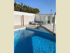 a house with a blue swimming pool with a patio at Paraiso House in Callao Salvaje