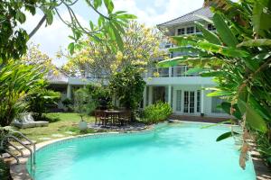 a swimming pool in front of a villa at Greenhouse Villa in Kerobokan