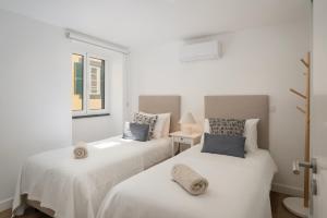 - 2 lits blancs dans une chambre avec fenêtre dans l'établissement Fort of Old Town Apartments by OurMadeira, à Funchal