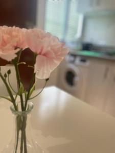 a vase with a pink flower sitting on a table at Apartamentos Lucero de Europa in Carmona +36 photos